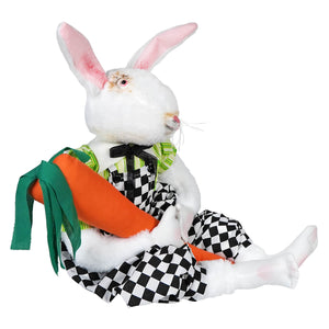 A plush white rabbit figurine from gallerie ii design by joe spencer dressed in checkered outfit holding carrot for easter display