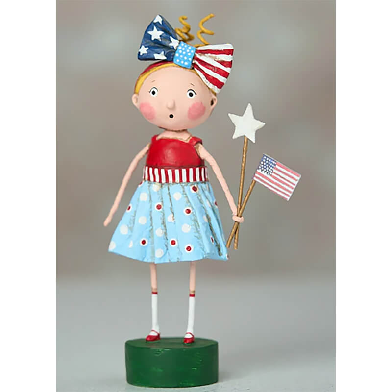 Patriotic folk art doll wearing an American flag bow, polka dot dress, and holding a star wand and flag.