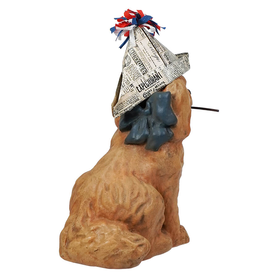Tan ceramic americana puppy dog figurine wearing a patriot paper hat with red white and blue tassels
