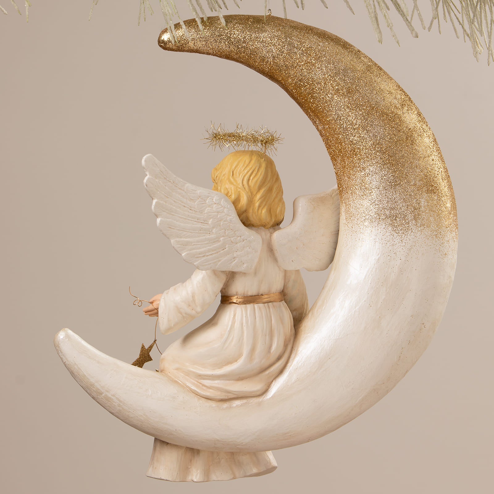 Delicate bethany lowe angel figure with golden hair white wings sits on a shimmering gold glitter crescent moon decor