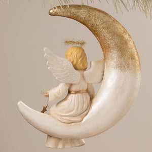 Delicate bethany lowe angel figure with golden hair white wings sits on a shimmering gold glitter crescent moon decor