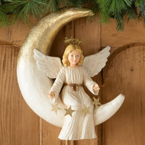 A white angel figurine with gold glitter wings seated on a crescent moon with stars from bethany lowe design angel figures and decor