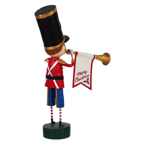 A festive red and blue toy soldier figurine with a black top hat holding a merry christmas banner announcing christmas