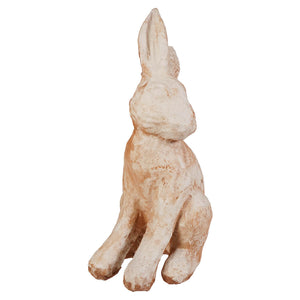 A rustic off-white ceramic antique waxed ivory sitting rabbit figurine with a weathered texture and earthy undertones