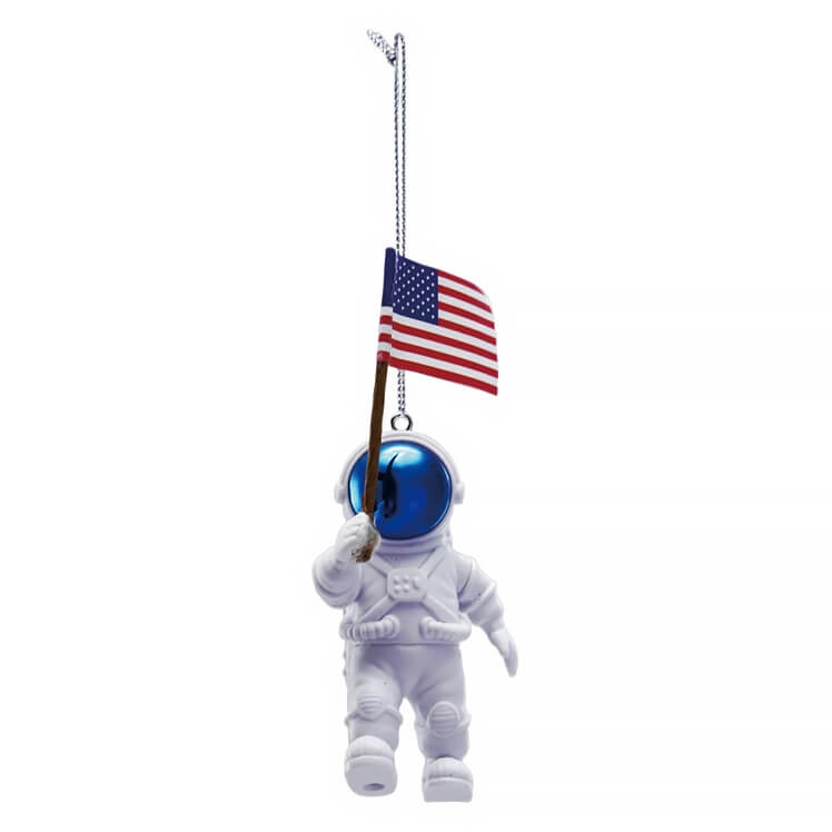 White astronaut ornament with reflective blue helmet holding an american flag ornament on a chain