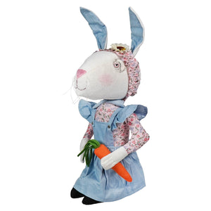 A charming white plush babble bunny with blue ears and denim dress holding a carrot from joe spencer spring and easter figures
