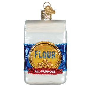 A clear glass bag of flour ornament with blue and red glittery accents and gold lettering, perfect figural decor