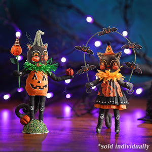 Two halloween figurines featuring a bat juggling cat girl in black dress and a pumpkin holding an orange lantern