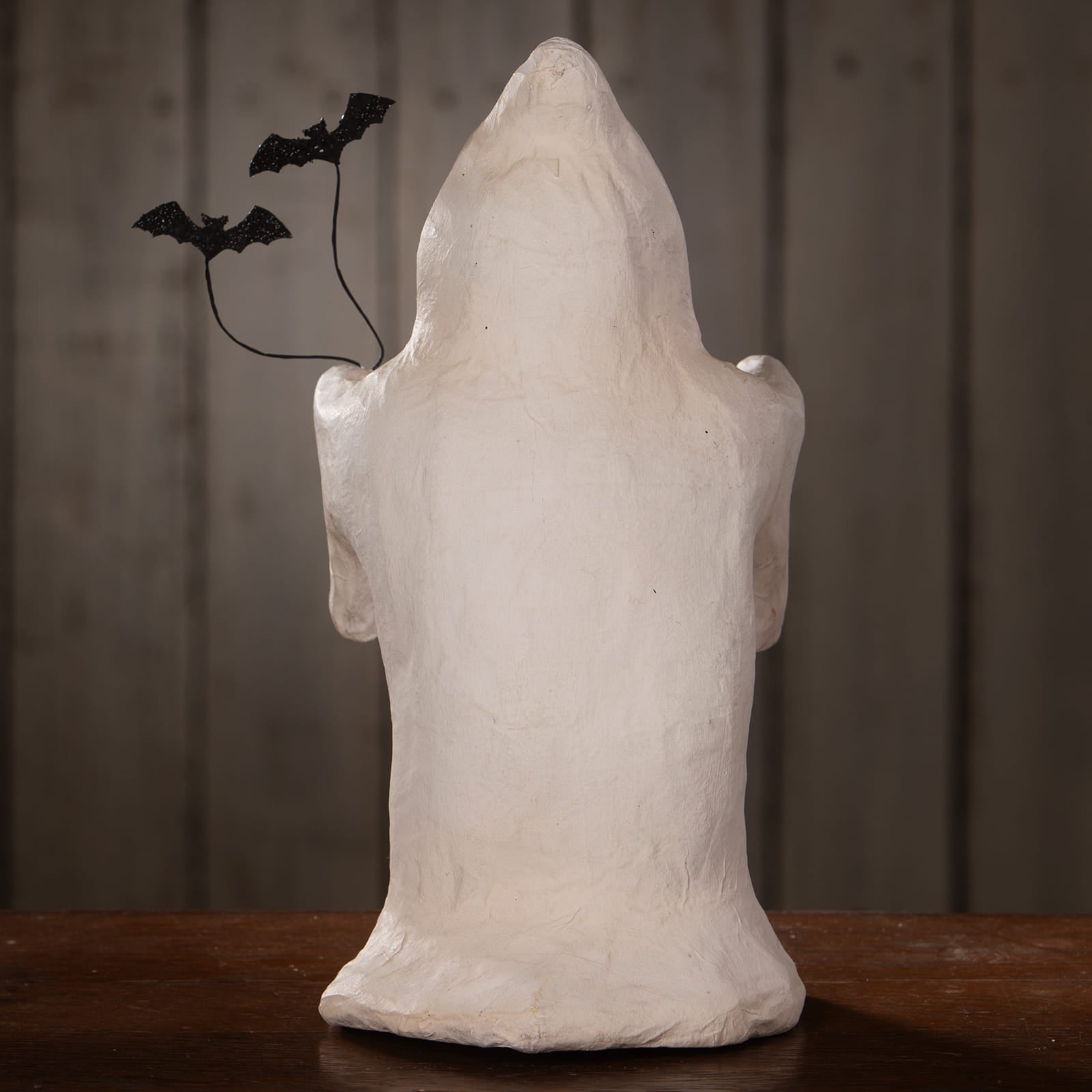 White paper mache batty boo halloween ghost figure decor with textured surface and black glitter bats on its shoulder