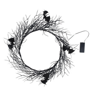 Black halloween wreath made of twisted branches with bat cutouts perfect for vintage easter and spring hanging decor