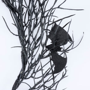 Black faux leather bat perched on dark twig branches in batty lighted wreath for vintage easter and spring hanging wall decor