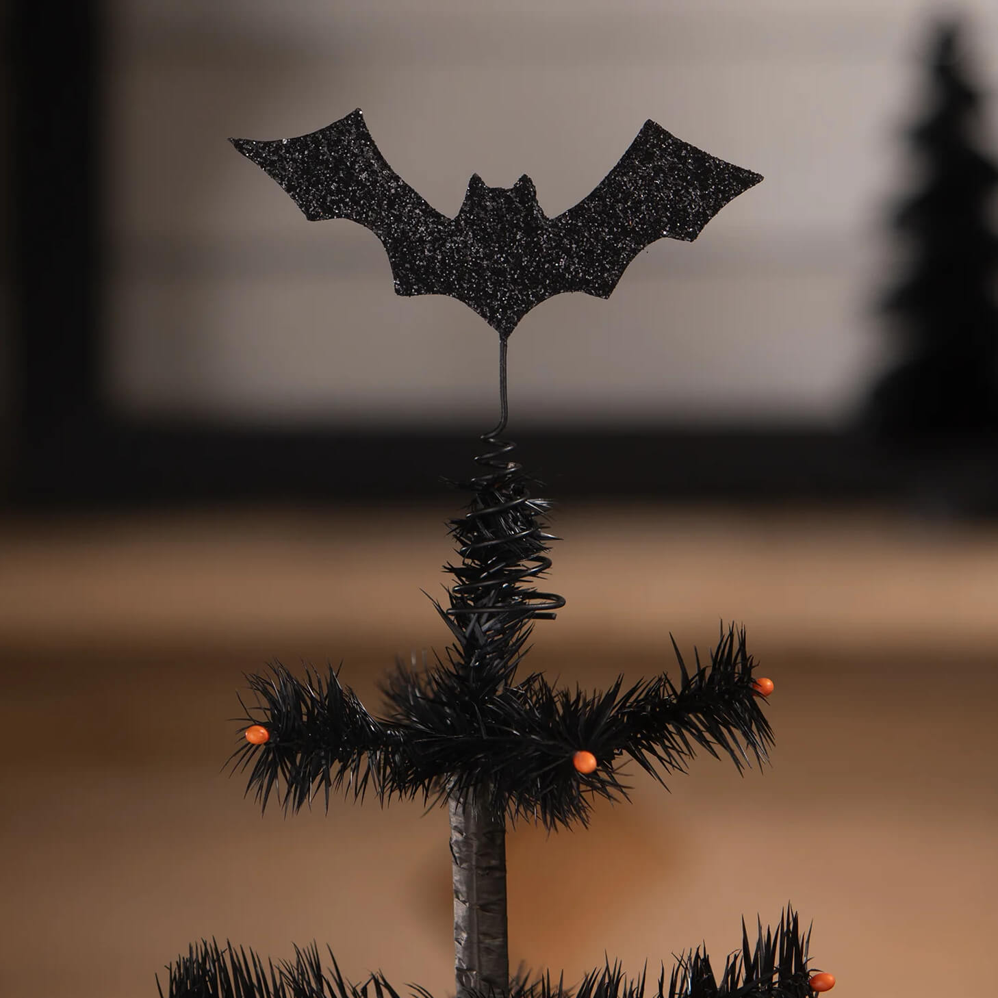 Black glitter batty tree topper on miniature black spider web tree by bethany lowe for spooky decor