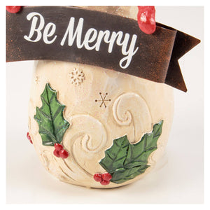 Cream-colored ceramic christmas snowman figurine with green holly leaves red berries and be merry banner decor