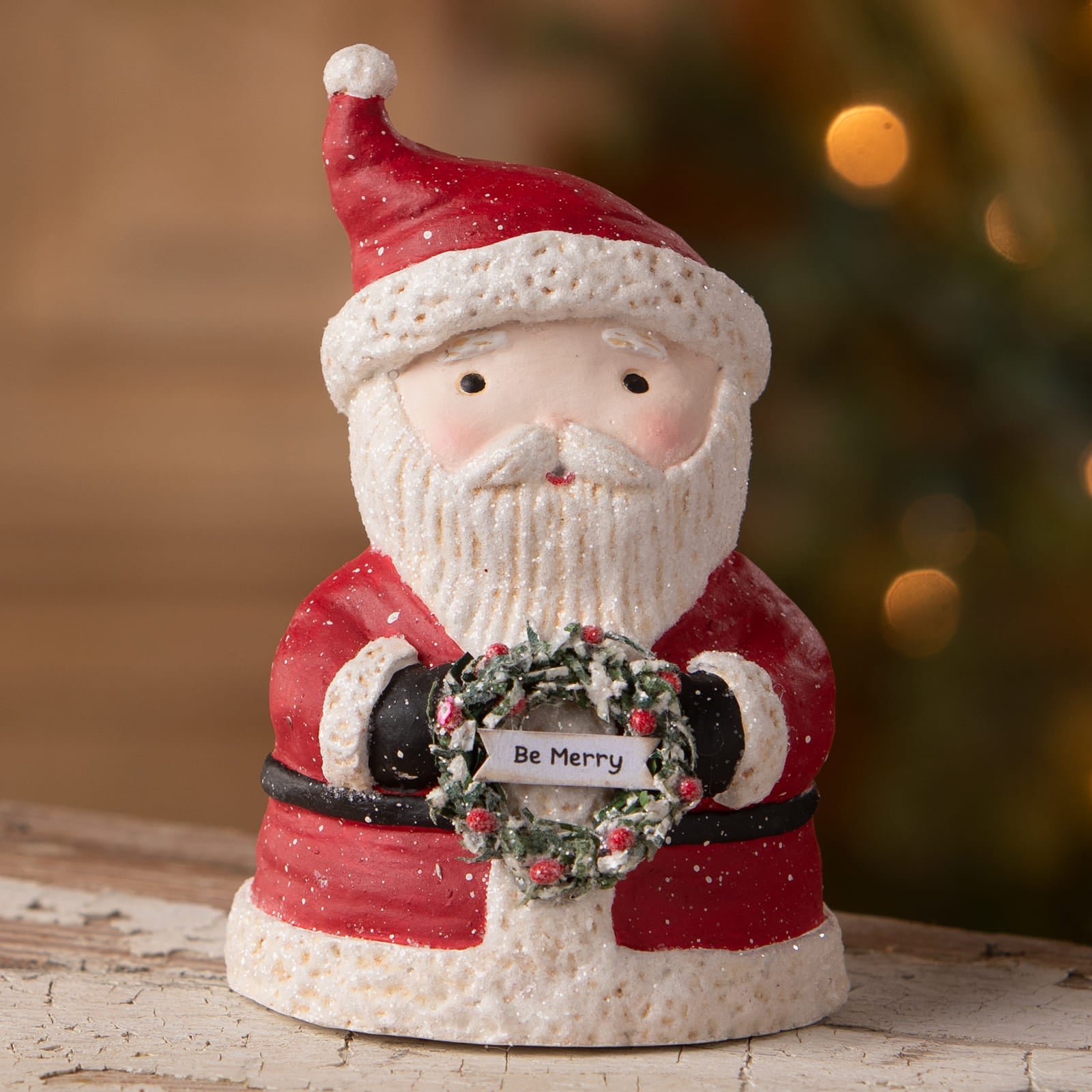 Red and white ceramic santa figurine holding a festive wreath with be merry from bethany lowe designs folk art santas