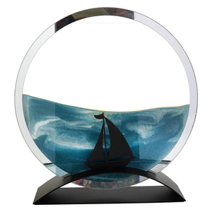 Beachcombers 10.5 inch sailboat round glass sand art with black sailboat silhouette and ocean-blue resin waves for figural decor