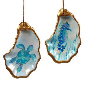 Two hand-painted oyster shell ornaments featuring a turquoise sea turtle and a blue seahorse for beachcombers coastal life