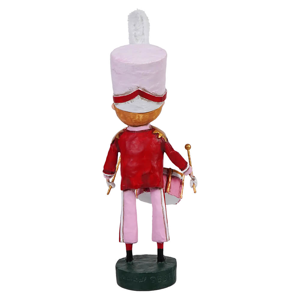 Decorative wooden nutcracker figurine in a red uniform with a tall white hat.