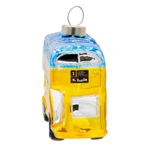 A vibrant yellow and blue glass beatles magical mystery tour bus ornament with glittery details and branding