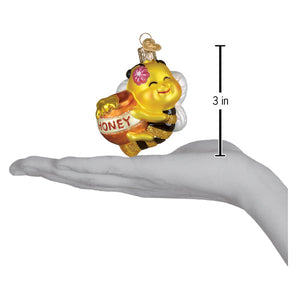 A cheerful yellow glass honey bee ornament holding a honey pot with a pink flower figural lighted decor