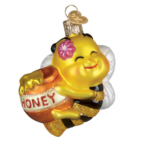 Bee sweet ornament is a cheerful yellow glass honey bee ornament with glittery gold wings holding an orange honey pot