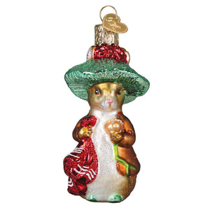 A charming glass benjamin bunny ornament with a green hat and red coat holding an acorn, perfect beatrix potters figural decor