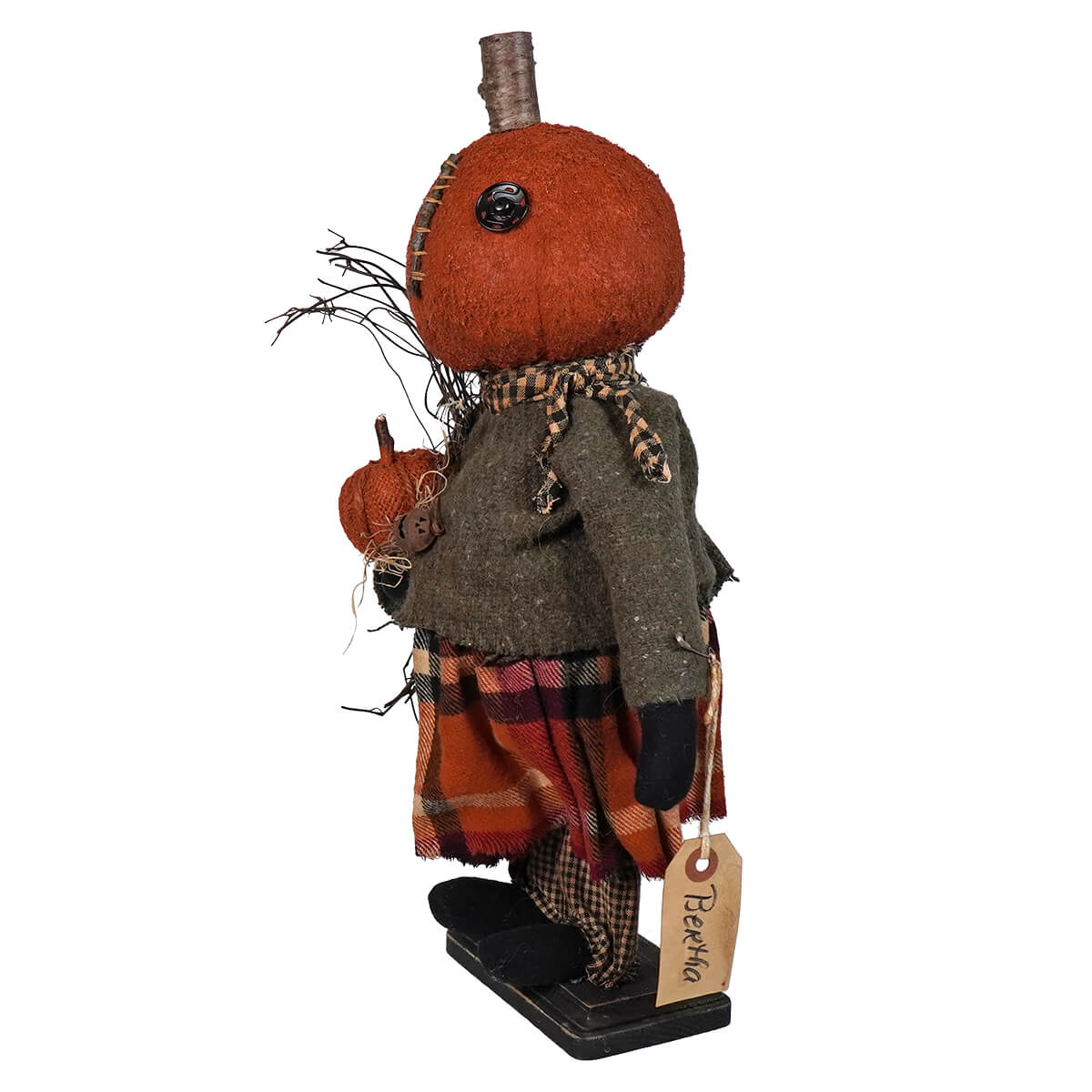 Whimsical pumpkin-headed figure wearing a plaid skirt, gray jacket, and black shoes.