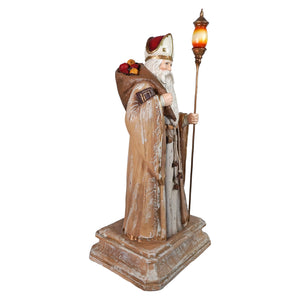 Bethany lowe designs life-sized antique st nicholas statue in beige white robe with gold trim holding a lit lantern