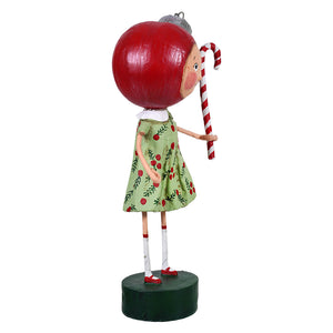 A whimsical betsy bauble figurine of a girl with a red apple head and cherry dress holding a candy cane perfect for a child’s christmas figures
