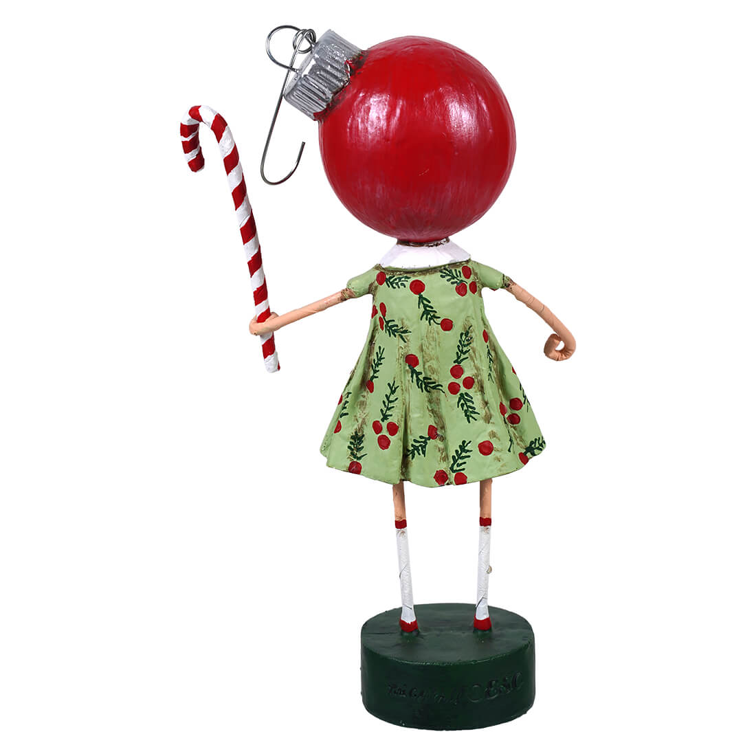 A whimsical betsy bauble figurine of a girl with a glossy red christmas ornament head in a green dress with red berries