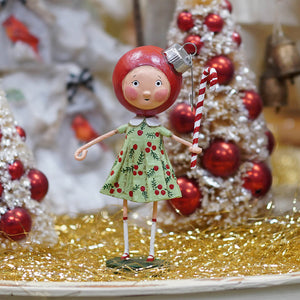 A charming red-headed betsy bauble doll in a green cherry dress holding a candy cane perfect for a child’s christmas figures
