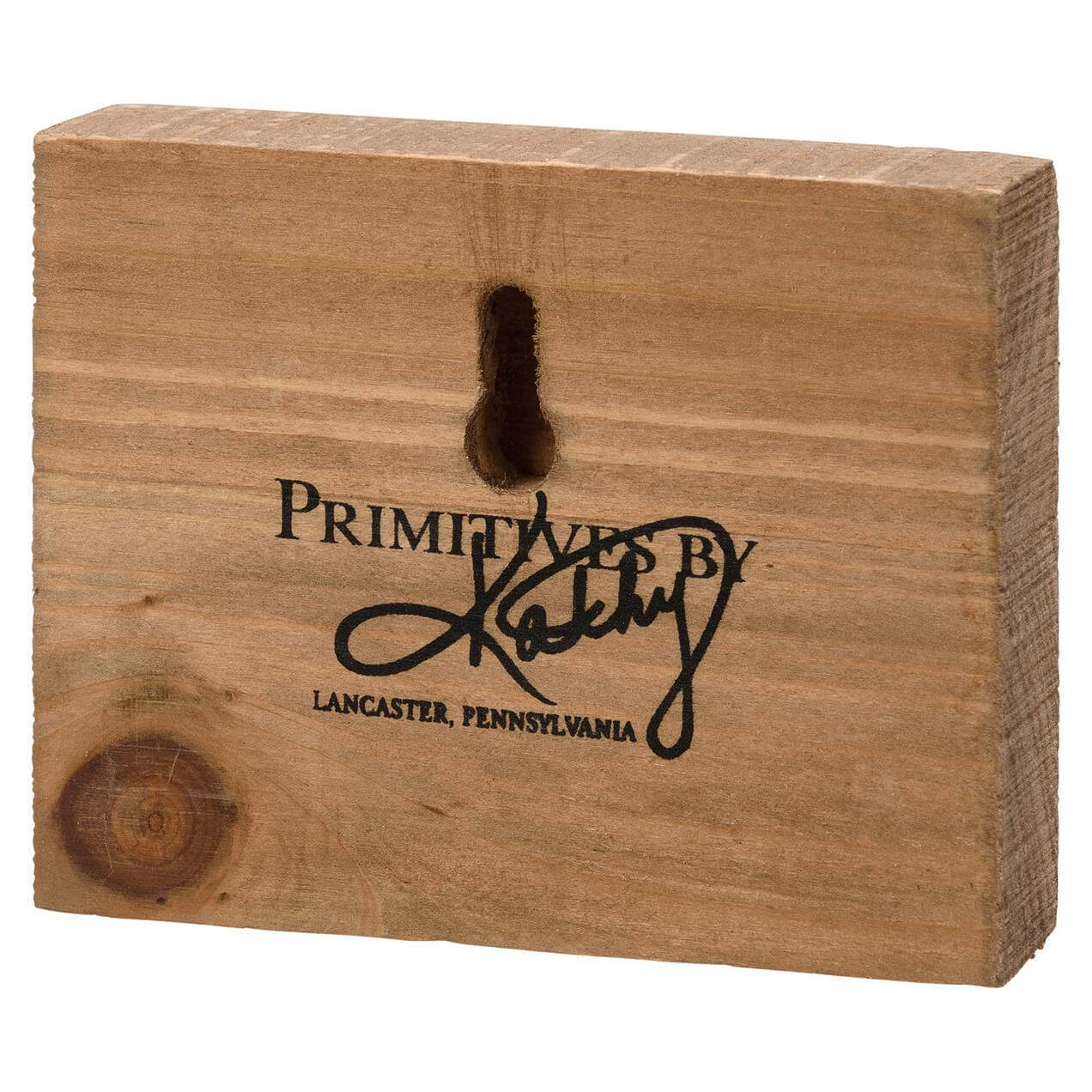 Wooden block with ’Primitives by Kathy’ and ’Lancaster, Pennsylvania’ engraved on it.