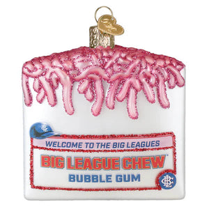 White glass christmas glass ornament shaped like a cake slice with pink glitter icing and big league chew label family owned