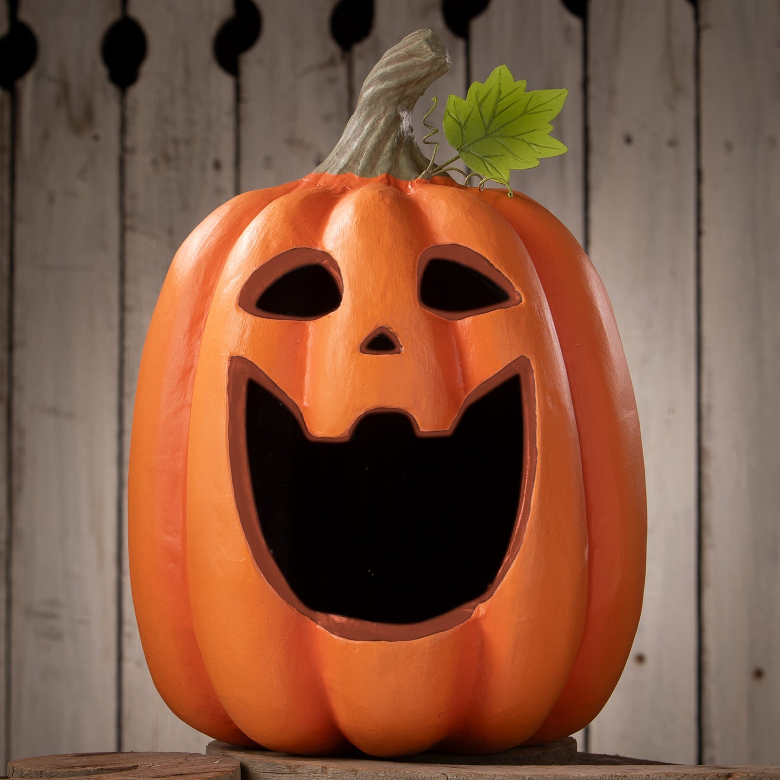 Orange plastic big mouth jack o lantern with carved face and green leaf perfect for halloween pumpkins and gourds displays