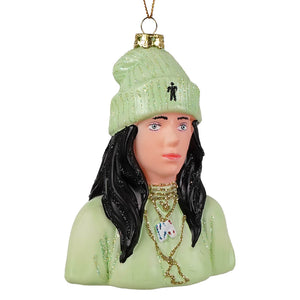 A mint green glittery beanie with a black logo on a billie eilish glass ornament featuring gold necklaces and black hair