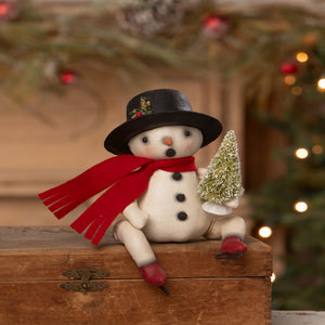 A charming white snowman figurine by bethany lowe designs wearing a black top hat and red scarf holding a frosted tree bing