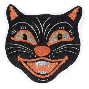 Black cat face shaped pillow with an embroidered black cat face patch featuring orange and white accents and a wide grin