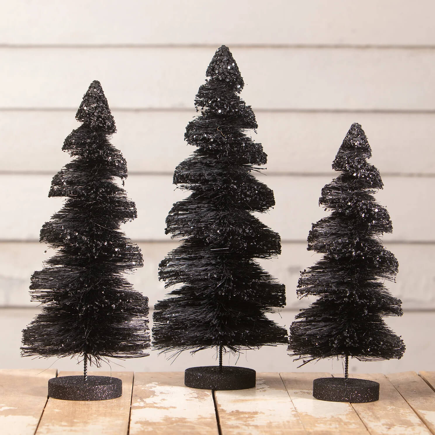 Three black glitter-frosted bottle brush trees on matching bases from black stripes delights bottle brush trees set