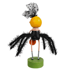 A lori mitchell halloween black widow figurine with an orange head, black dress, striped stockings, and polka dot bow on green base
