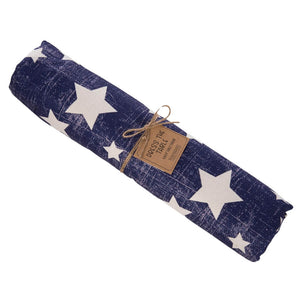 Rolled navy blue fabric with white star pattern and brown paper tag attached by twine.