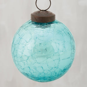 A blue ball glass ornament with turquoise crackled glass and a rustic brown metal cap for hanging