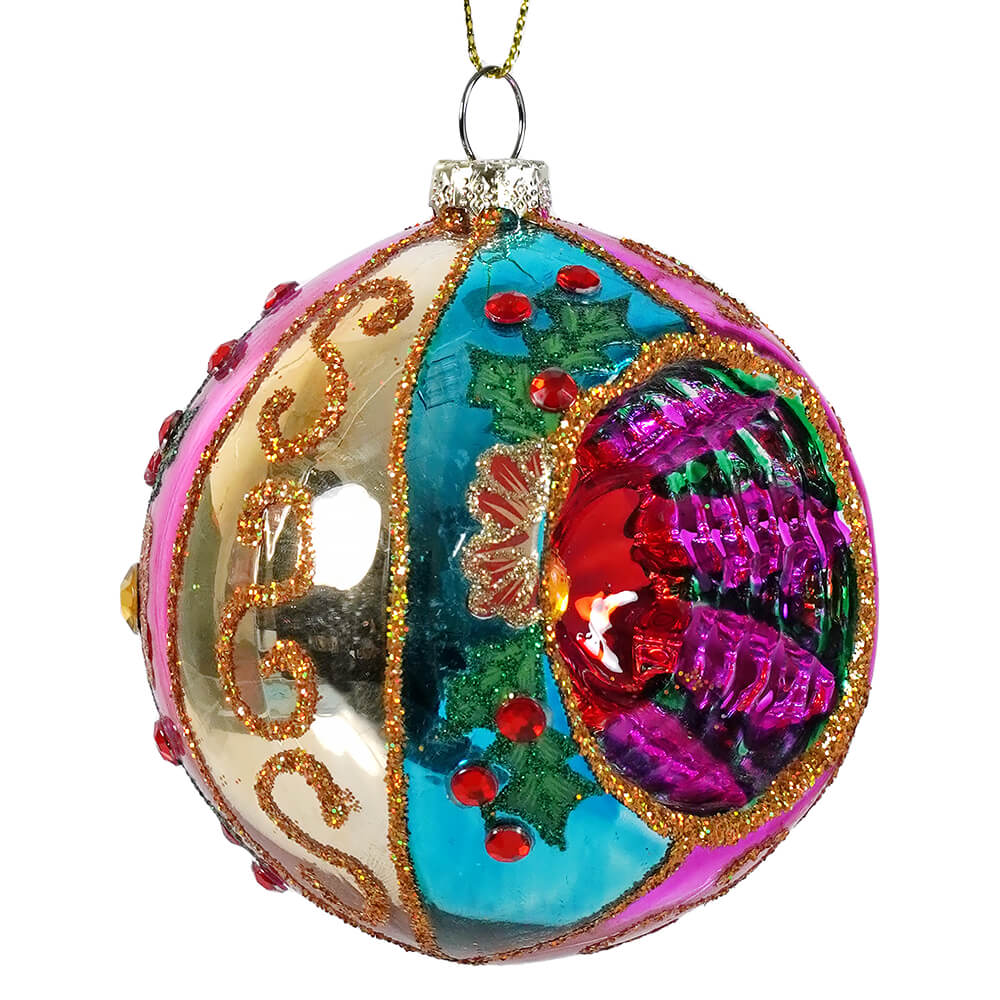 A vibrant ball witch eye ornament with purple floral design, gold glitter swirls, pink teal sections, and red gems