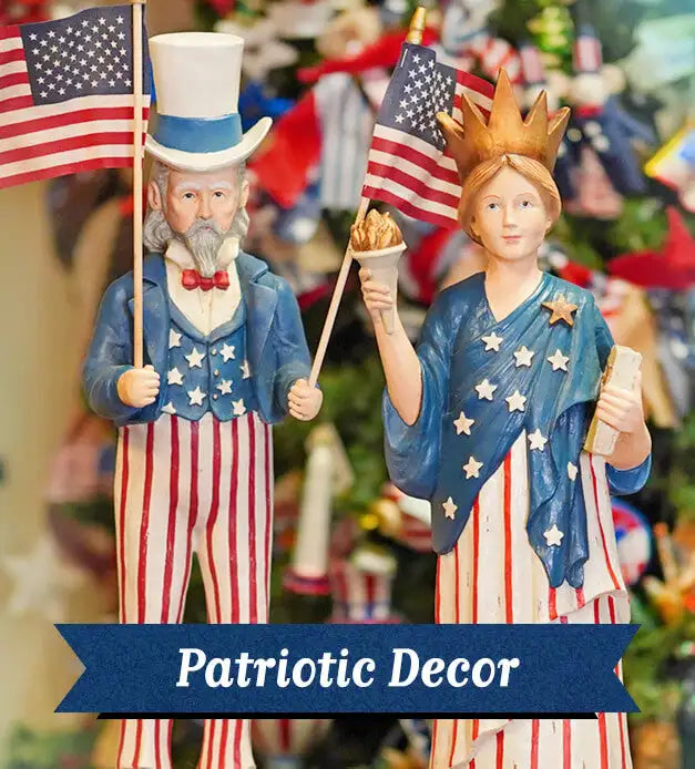 Blue and red patriotic figurines of uncle sam and the statue of liberty, each holding an american flag.