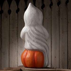 White halloween ghost figures decor with flowing fabric draped over an orange jack o lantern pumpkin base