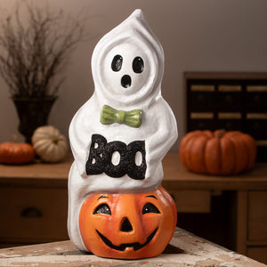 White halloween ghost figure with black eyes mouth green bow tie and glittery boo on orange jack o lantern ornament