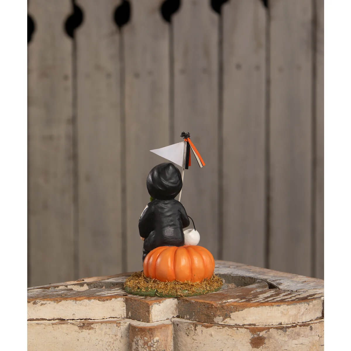 Black bethany lowe design boo to you oliver figurine of a child in hooded outfit sitting on an orange pumpkin with tassels
