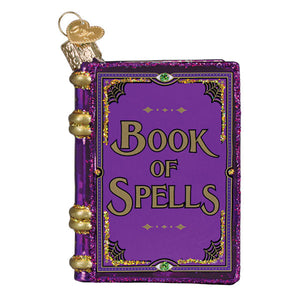 Purple glittery glass book of spells ornament with gold lettering and spiderweb borders perfect figural decor