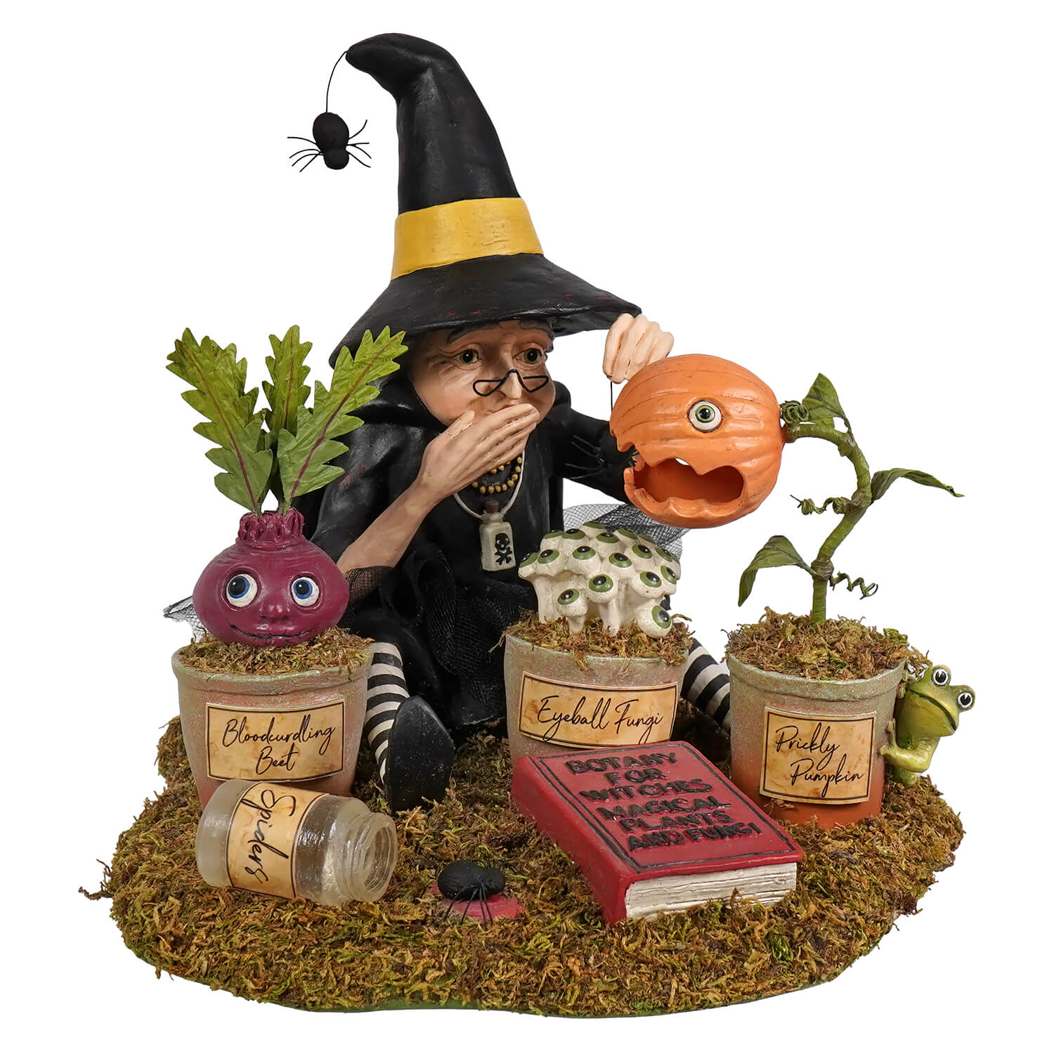 A black botany witch figurine with yellow hat band and striped socks surrounded by halloween witches garden plants