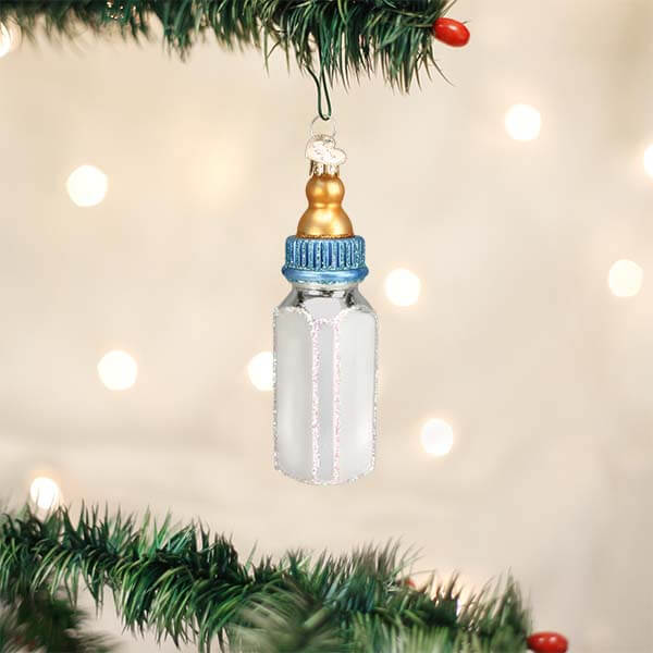 Delicate glass boy baby bottle ornament with gold cap, blue ribbed ring, frosted white body, and sparkling glitter