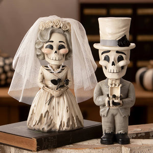 A charming white and gray skeleton bride and groom figurine set dressed in wedding attire in the groom skelly bundle