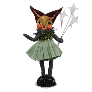 A whimsical bride of frankenstein figurine with painted face wearing green pleated skirt holding star decorations on sequined base